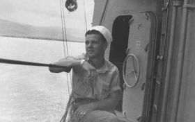 photograph of Ed Russell on deck of the DER-386, shakedown cruise to Gua