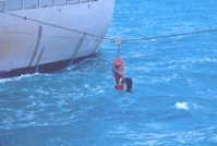 photograph of crewmember leaving the ship by breeches buoy