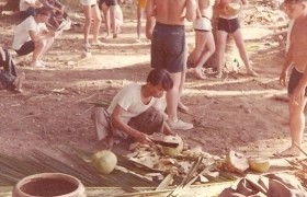 photograph of Vietnamese man opening coconut