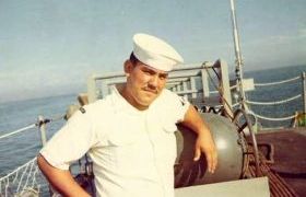 photograph of Ernie leaning against the depth charge rack that he was responsible for 