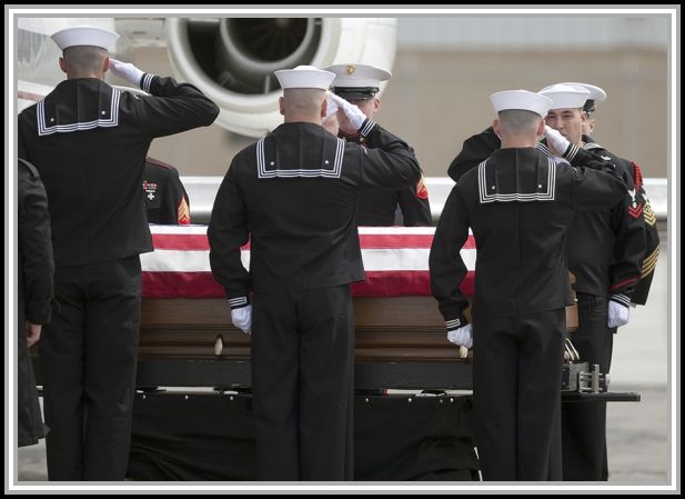 photograph of sailors saluting coffin